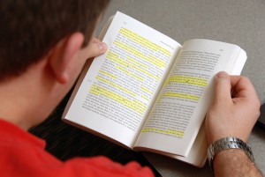 Political science student reads over study materials prior to class in Caldwell Hall.