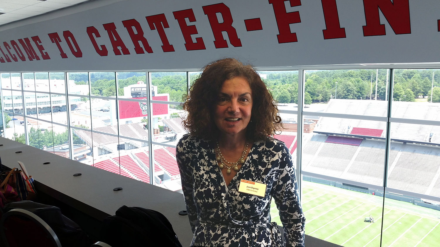 Jean Bigoney at one of the Jenkins Professional Online MBA Program Raleigh Residency events. Jean is pictured in the suites at Carter Finley Stadium overlooking the field.