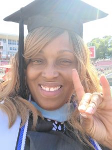 Sherika Lee does the Wolfpack hand sign at the commencement ceremony at Carter-Finley Stadium.