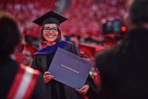 Spring 2018 graduate pose for a photo in her regalia.